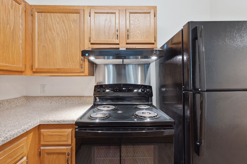 a kitchen with wood cabinets and black appliances