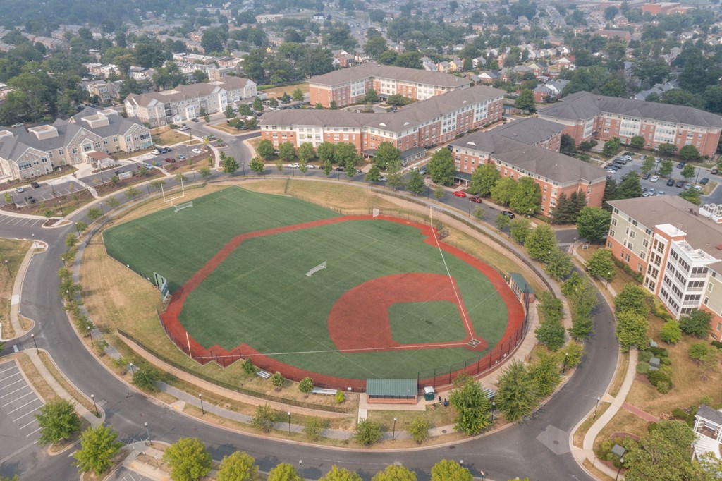 an aerial view of a baseball field with buildings in the background