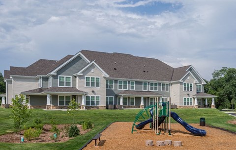 a playground in front of a large house