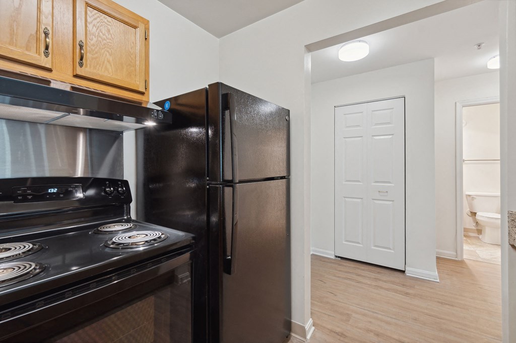 a kitchen with black appliances and wood flooring