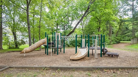 A playground with a slide, swings, and a bench.