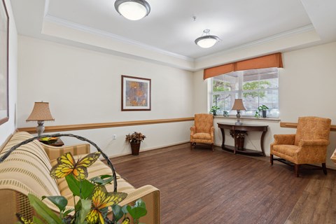 a living room with a couch and chairs and a window