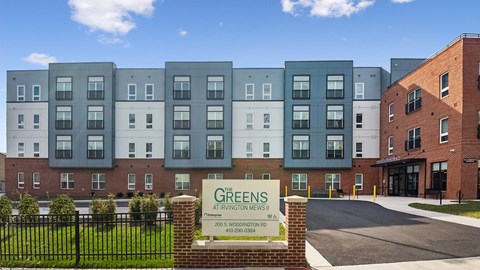 The image shows a building with the name GREENS on it.