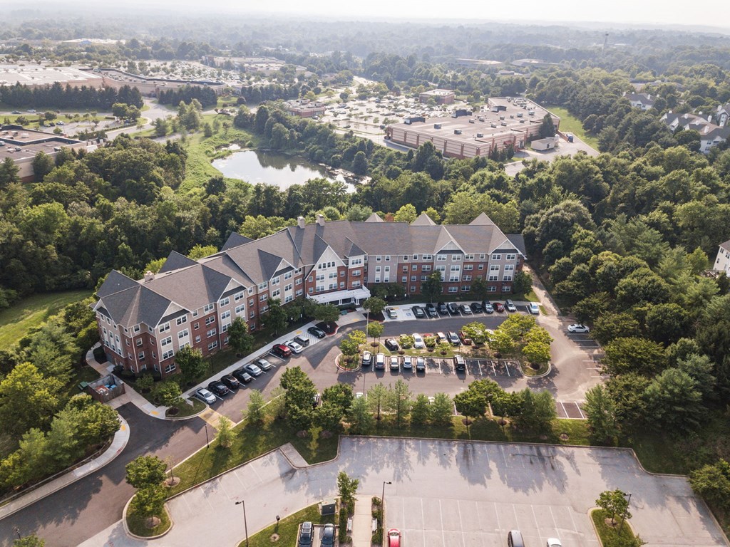 an aerial view of a large building surrounded by trees and a parking lot