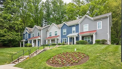 A row of houses with a flower bed in the front.