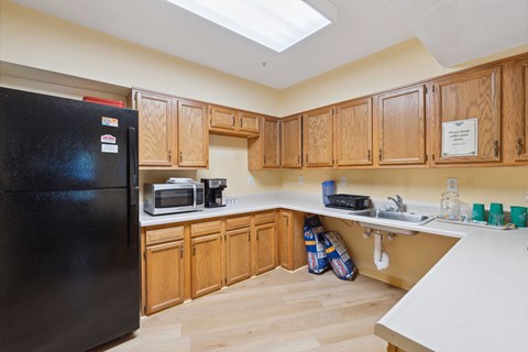 a kitchen with wooden cabinets and a black refrigerator