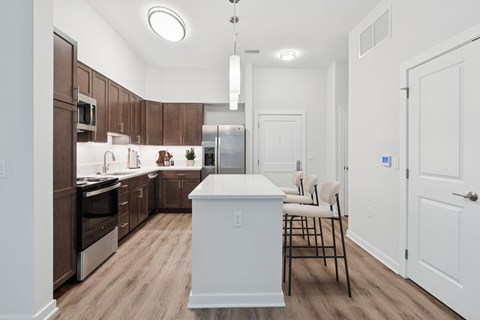 A kitchen with brown cabinets and a white island.