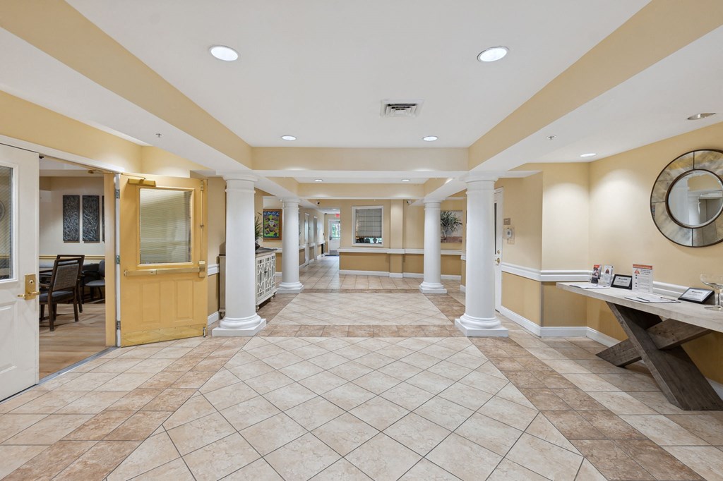 a lobby with a table with a mirror on the wall