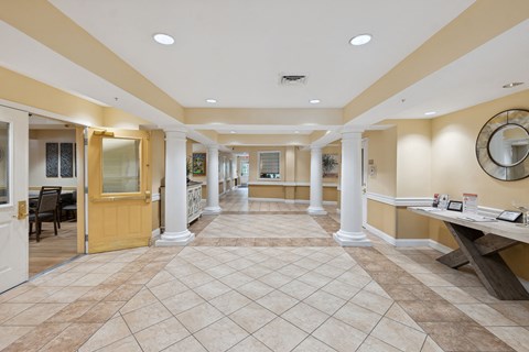 a lobby with a table with a mirror on the wall