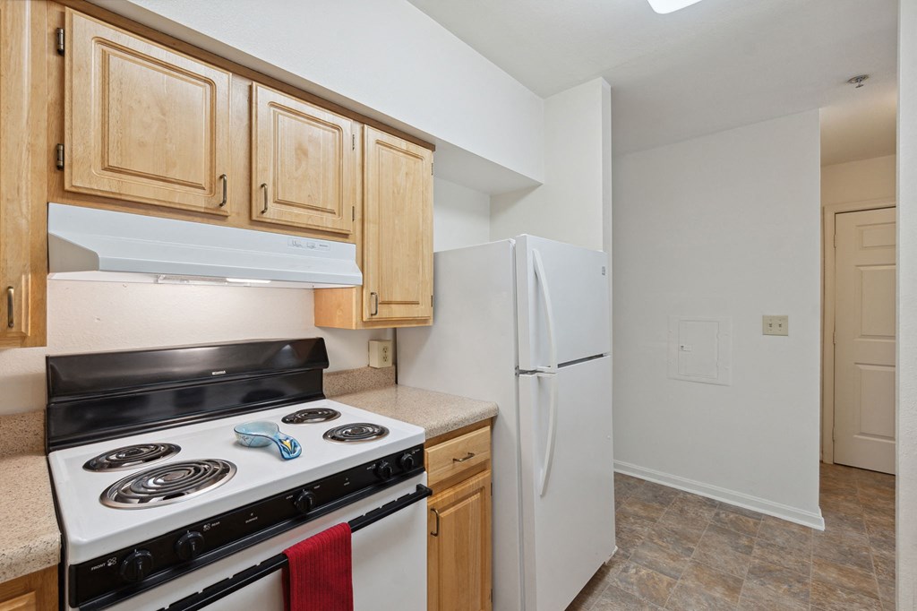 a kitchen with wood cabinets and white appliances
