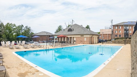 A large outdoor swimming pool with a building in the background.