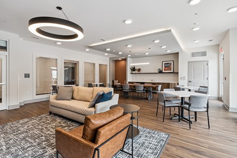 A modern living room with a brown leather sofa and a grey rug.