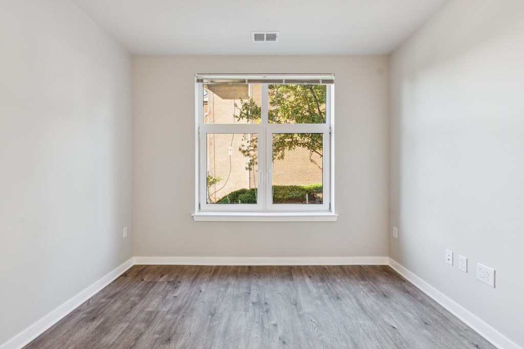 A room with a window and wooden flooring.