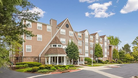 A large apartment complex with a central courtyard and a variety of trees.