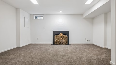 A room with a fireplace and carpeting.