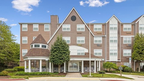 A large apartment complex with a gazebo-like structure in the front.