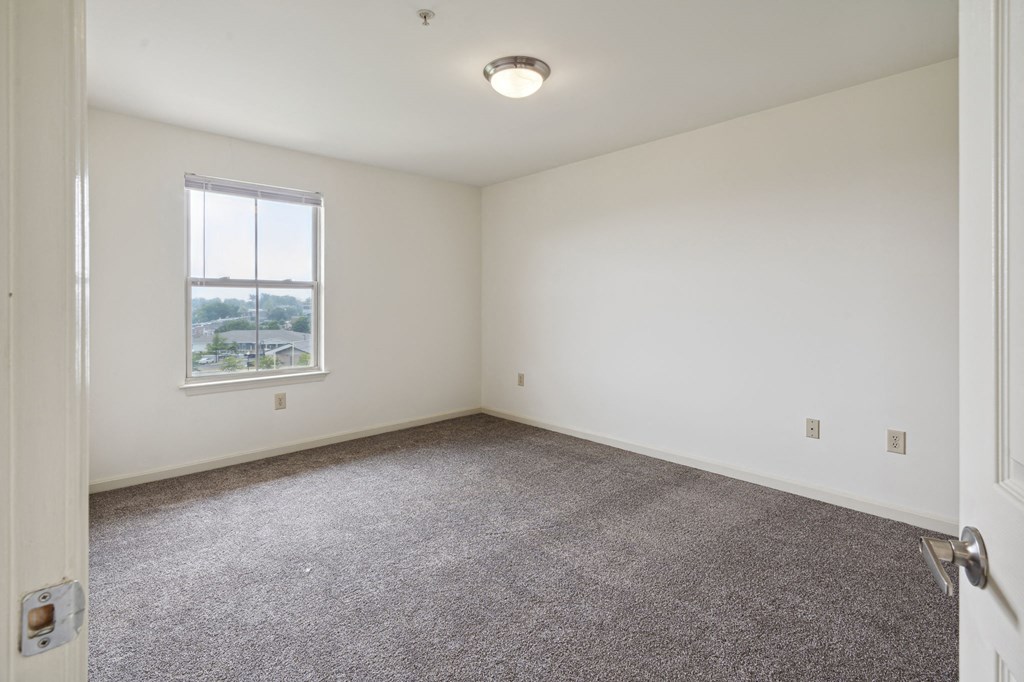 a bedroom with white walls and carpet