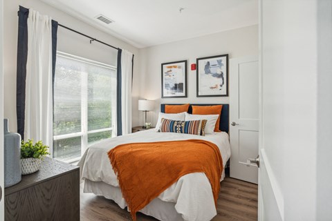 a bedroom with a bed and a large window