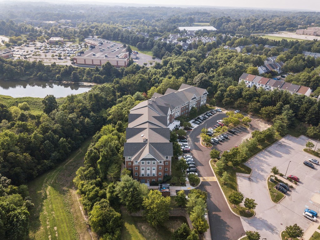 an aerial view of a large building surrounded by trees and a river