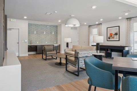 A modern living room with a grey carpet and a variety of furniture.