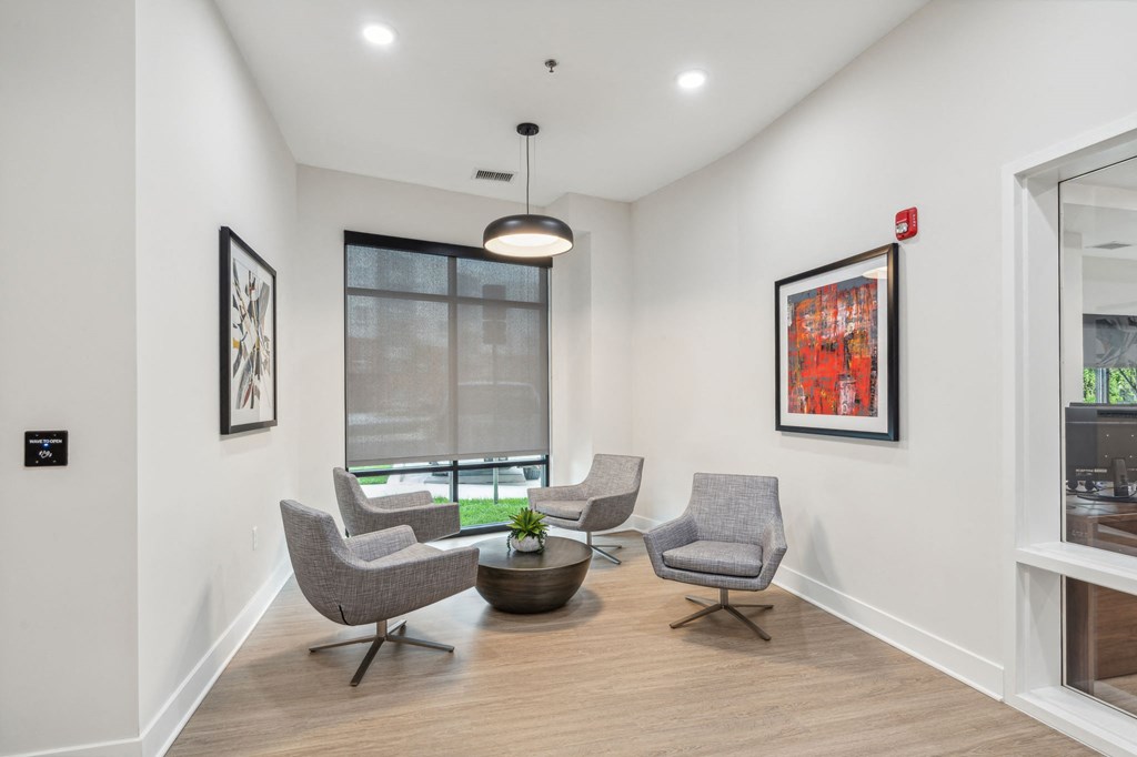 Community seating space with two chairs, a table and large window at Legacy at Twin Rivers