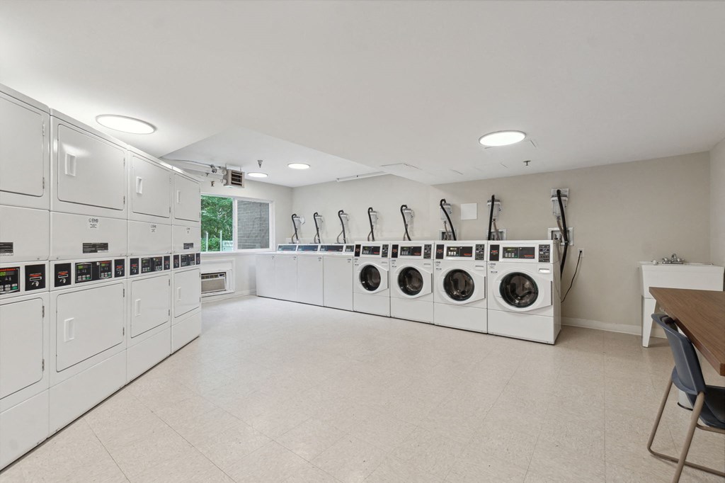 a large laundry room with washers and dryers
