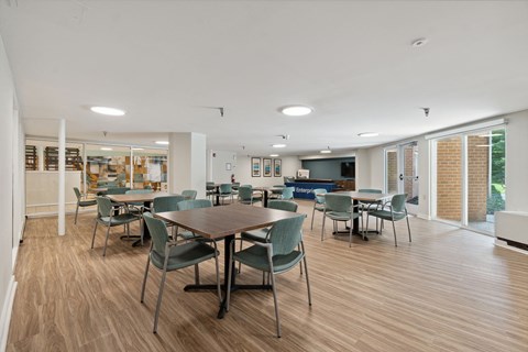 a dining room with tables and chairs and a kitchen