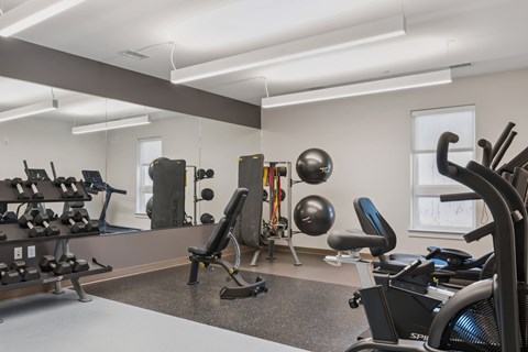 A gym with a variety of equipment including weights and machines.
