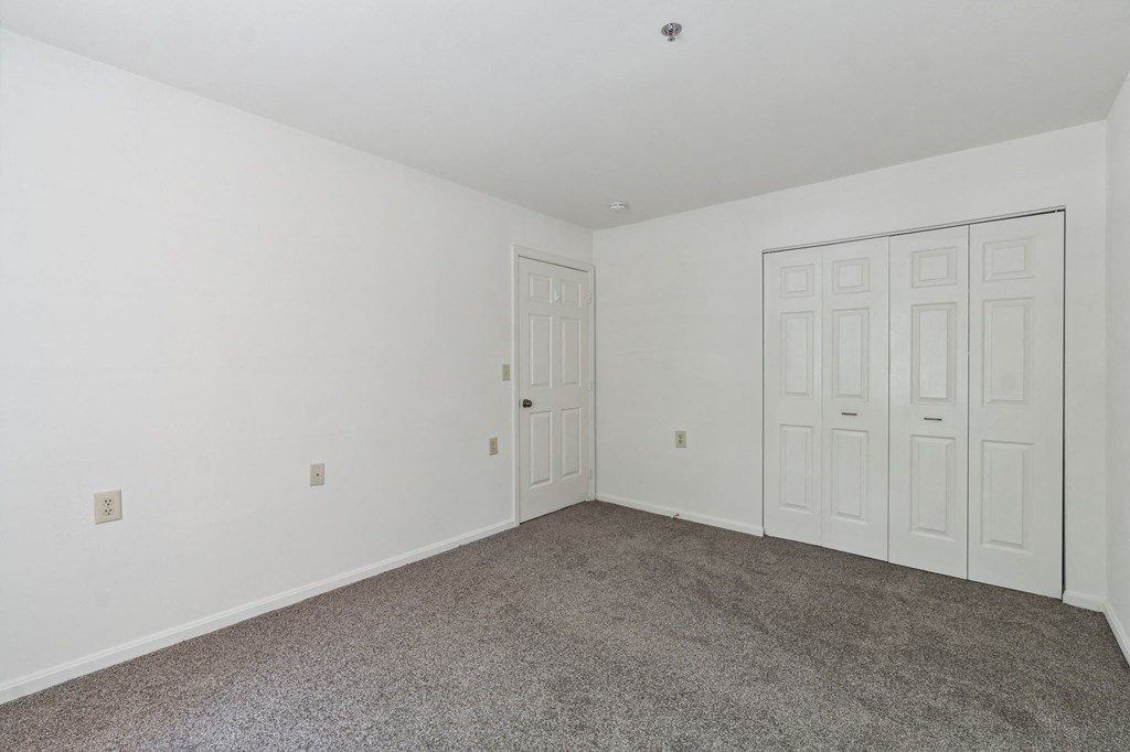 a bedroom with two doors and a carpeted floor