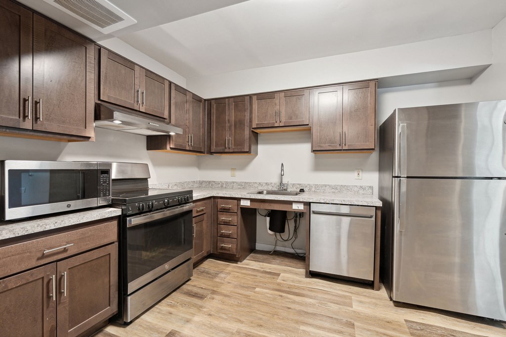 a kitchen with wooden cabinets and stainless steel appliances