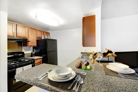 a kitchen with black appliances and a granite counter top
