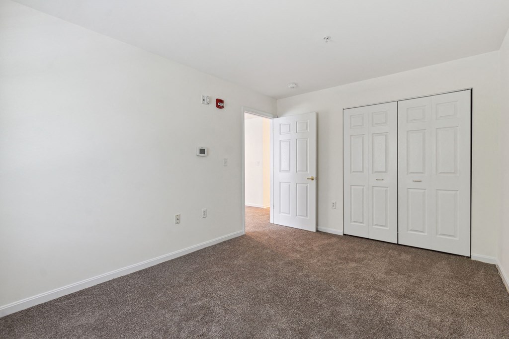 a bedroom with two doors and a carpeted floor