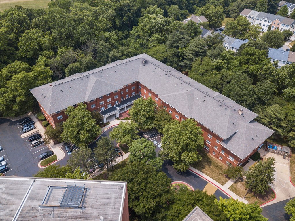 an aerial view of a red brick building with a grey roof
