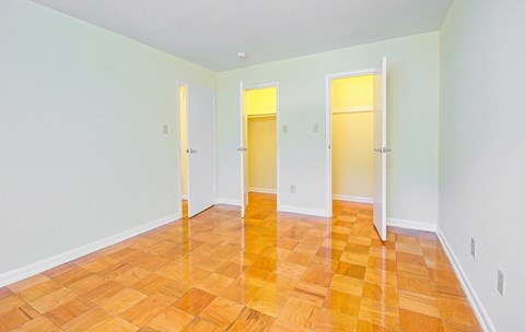 a empty living room with wood flooring and white walls