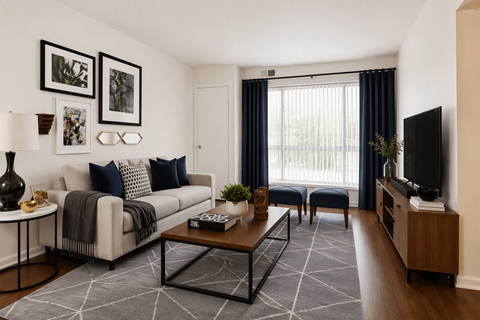 A living room with a white couch, a coffee table, and a television.