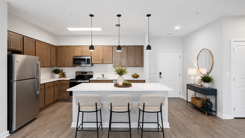 A modern kitchen with a white island and bar stools.
