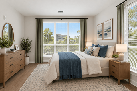 A bedroom with a large bed and a view of the outside through the window.