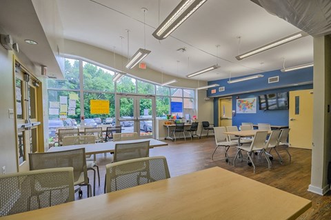 a dining room with tables and chairs and a large window