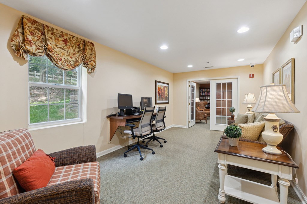 a home office with carpeted flooring and beige walls