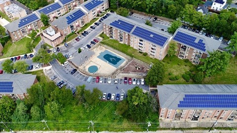 an aerial view of a building with solar panels on the roof