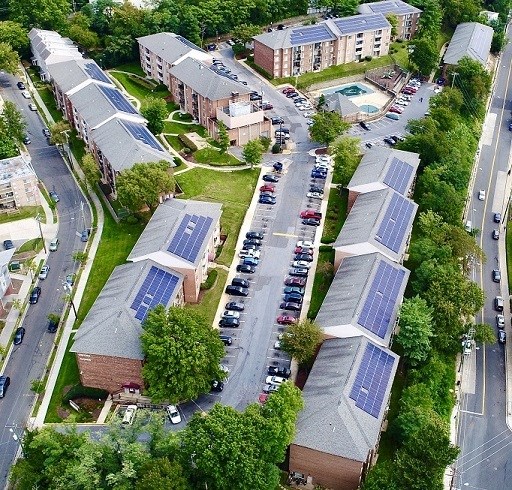 an aerial view of some buildings with solar panels     and a street