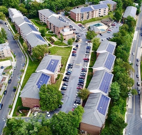 an aerial view of some buildings with solar panels     and a street