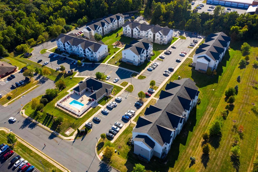 an aerial view of houses and cars in a parking lot