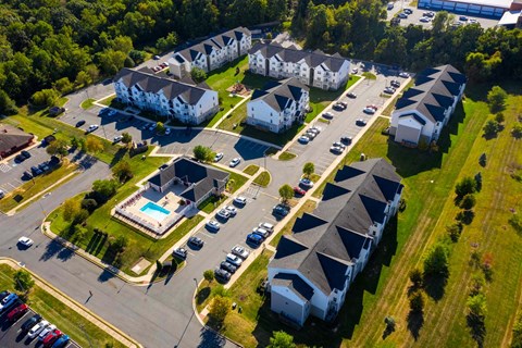 an aerial view of houses and cars in a parking lot
