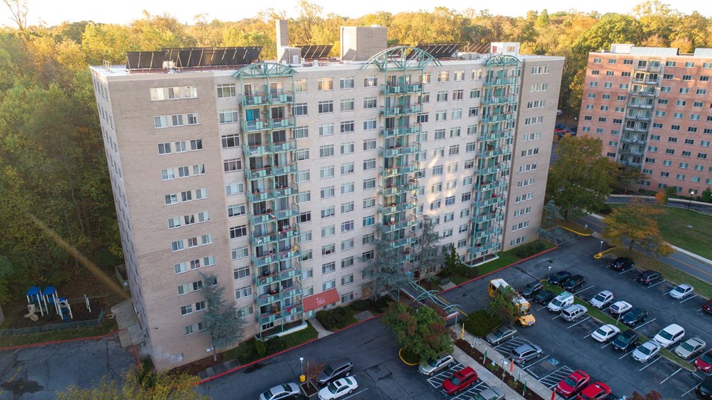 a view of a large apartment building from above with a parking lot