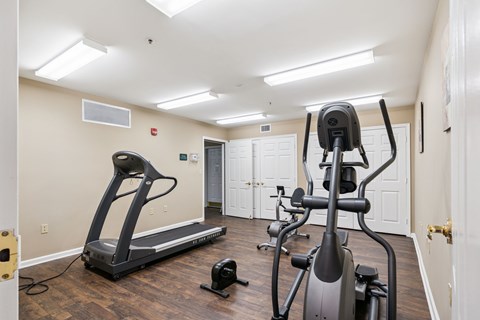 A home gym with a treadmill, elliptical trainer and a stationary bike.
