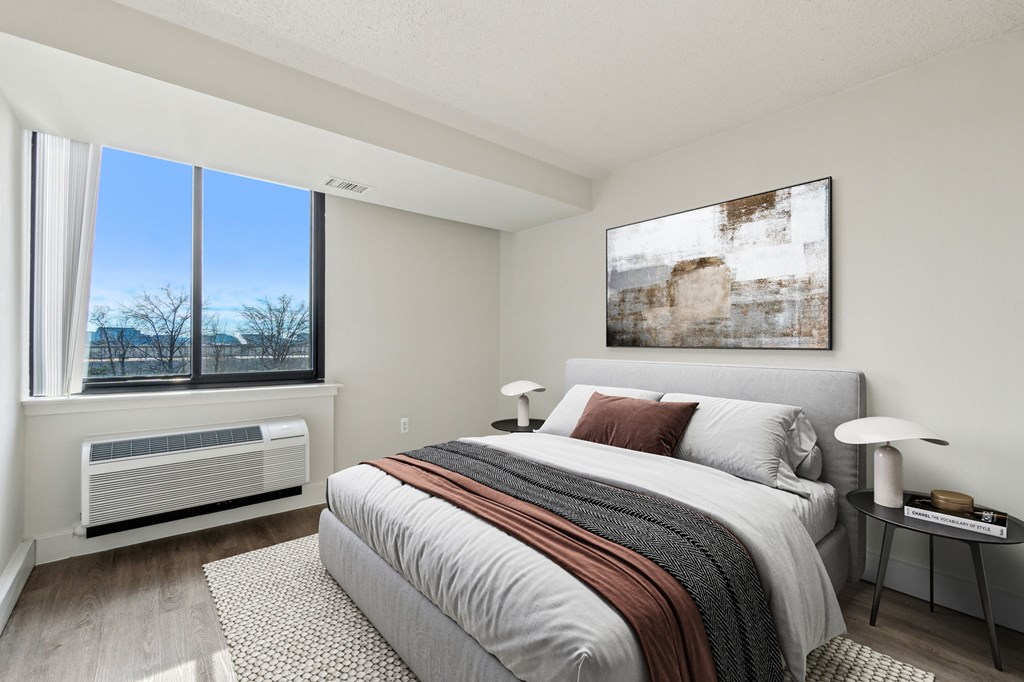 Bright, airy bedroom in a market-rate 2-bedroom apartment at Edgewood Commons 611 & Gardens, with generous closet space, luxury vinyl flooring, and plenty of natural light—ideal for comfort and rest.