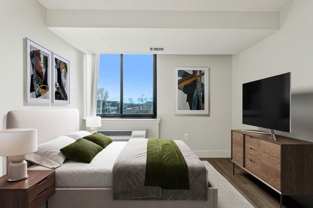 Bright, airy bedroom in a market-rate 2-bedroom apartment at Edgewood Commons 611 & Gardens, with generous closet space, luxury vinyl flooring, and plenty of natural light—ideal for comfort and rest.