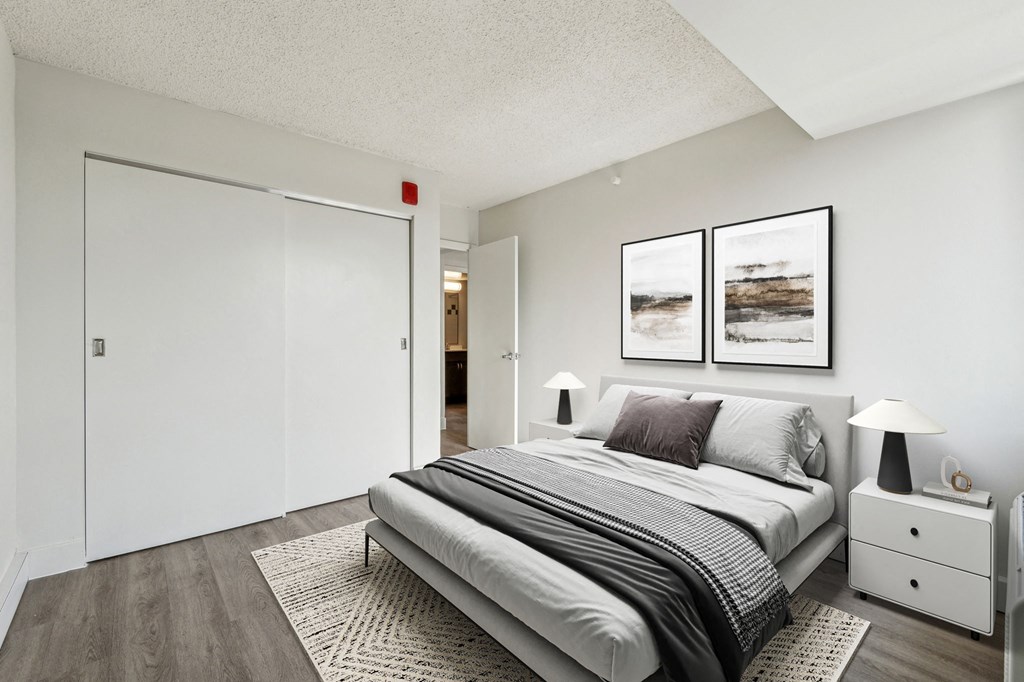 Bright, airy bedroom in a market-rate 2-bedroom apartment at Edgewood Commons 611 & Gardens, with generous closet space, luxury vinyl flooring, and plenty of natural light—ideal for comfort and rest.