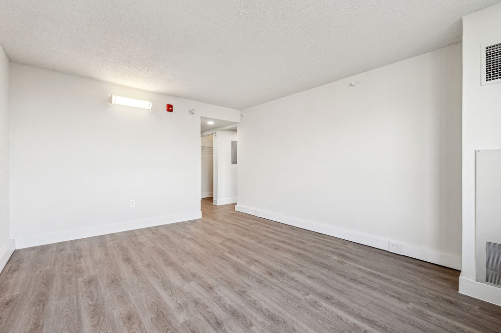 Bright, airy bedroom in a market-rate 2-bedroom apartment at Edgewood Commons 611 & Gardens, with generous closet space, luxury vinyl flooring, and plenty of natural light—ideal for comfort and rest.